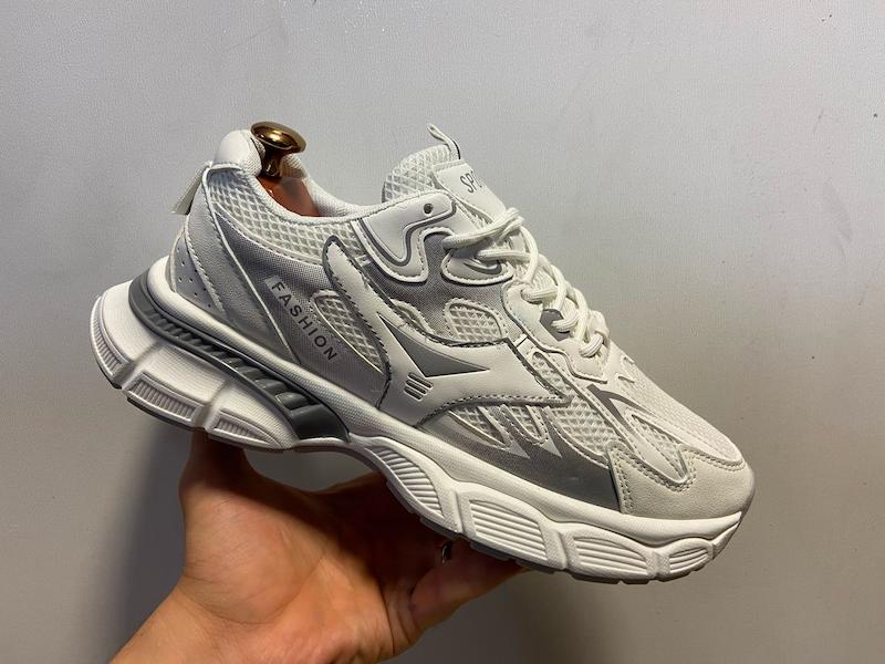  کتونی اسپرت مردانه طوسی روشن با ترکیب مش تنفس‌پذیر و چرم صنعتی، ساختار چندلایه مقاوم، زیره EVA ضربه‌گیر، مناسب استایل روزمره؛ ثبت تصویر از زاویه کناری روی دست