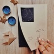 دفتر یادداشت با طرح خانه فانتزی و ماه کنار نشانگر کتاب دست ساز