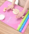 ورز دادن خمیر شیرینی و نان روی مت سیلیکونی رنگ صورتی با وردنه