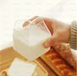 لیوان شیشه‌ای دوجداره پاکت شیر با نوشیدنی سرد قرمز و فوم سفید، تزئین شاخه رزماری