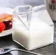 لیوان شیشه‌ای دوجداره طرح پاکت شیر با نوشیدنی زرد و کف شیر، تزئین توت قرمز