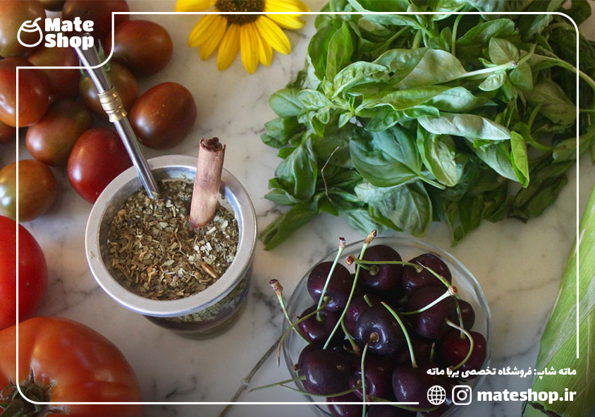 یک لیوان ماته در کنار میوه و سبزیجات تازه