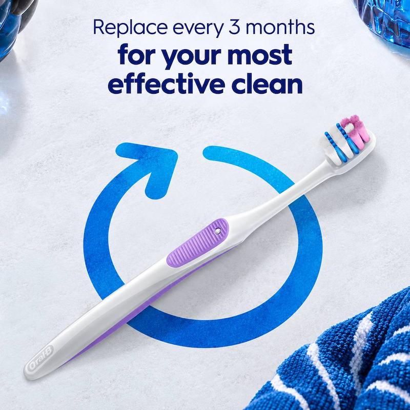 نمای نزدیک سر مسواک Oral-B با الیاف صورتی، آبی و سفید و بدنه سفید