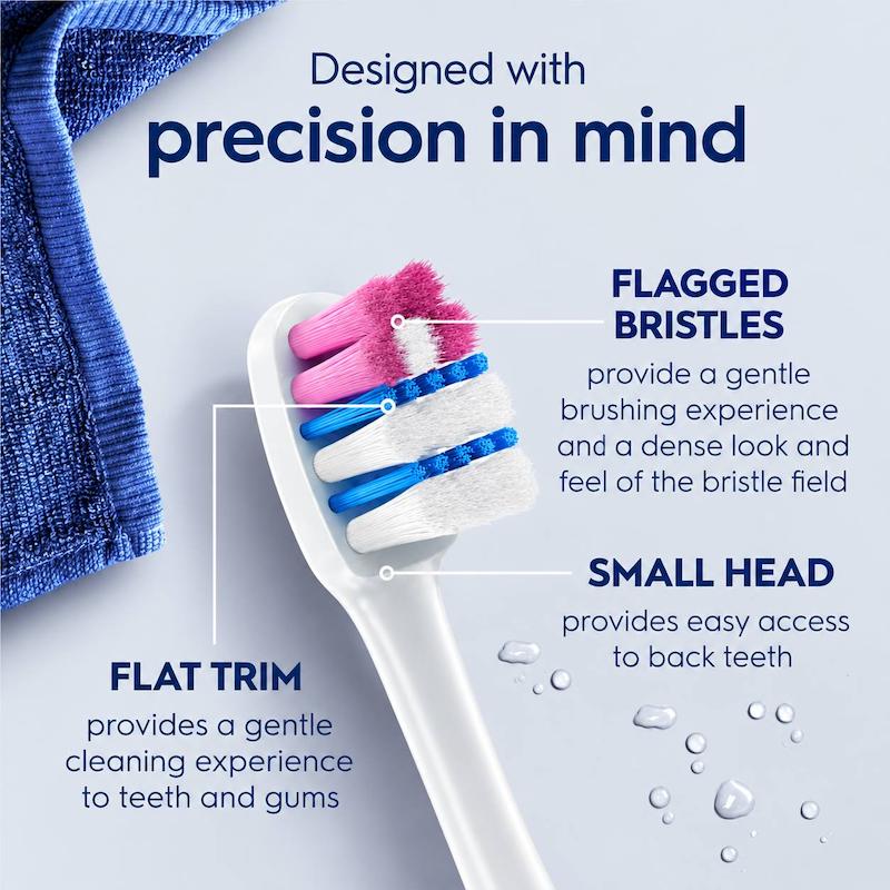 نمای نزدیک سر مسواک Oral-B با الیاف صورتی، آبی و سفید و بدنه سفید