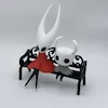 فیگور Hollow Knight و Silksong Hornet روی نیمکت