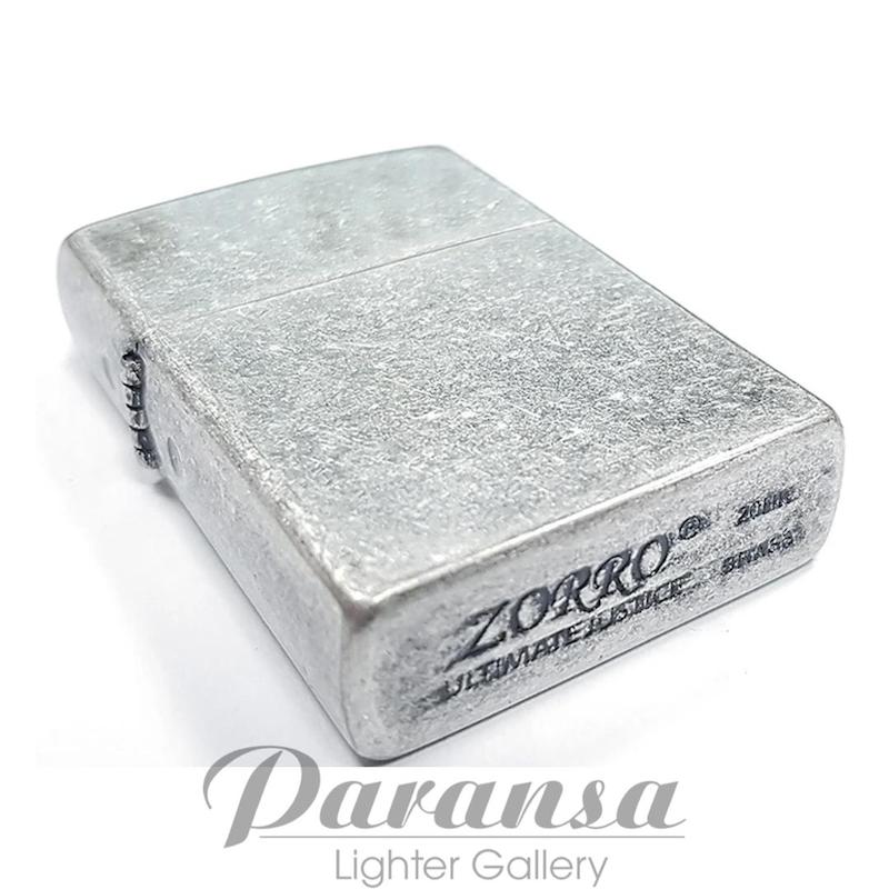 تصویر فندک زورو بنزینی نقره‌ای آنتیک با طراحی سبک ریپو و بدنه فلزی با فینیش آنتیک، همراه با جعبه و بنزین کوچک