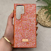 قاب گوشی Galaxy S24 Ultra سامسونگ نگین دار سواروسکی SWAROVSKI پلاک فلزی نارنجی کد 151355