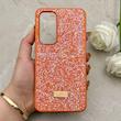 قاب گوشی Galaxy S24 FE سامسونگ نگین دار سواروسکی SWAROVSKI پلاک فلزی نارنجی کد 153045