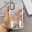 قاب گوشی iPhone 17 آیفون طلقی شفاف شیشه ای فانتزی دارای آویزبند چرمی فلزی طرح گل های بابونه کد 153827