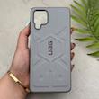 قاب گوشی Galaxy A12 - M12 سامسونگ UAG Design سیلیکونی ژله ای محافظ لنز دار طوسی کد 163048