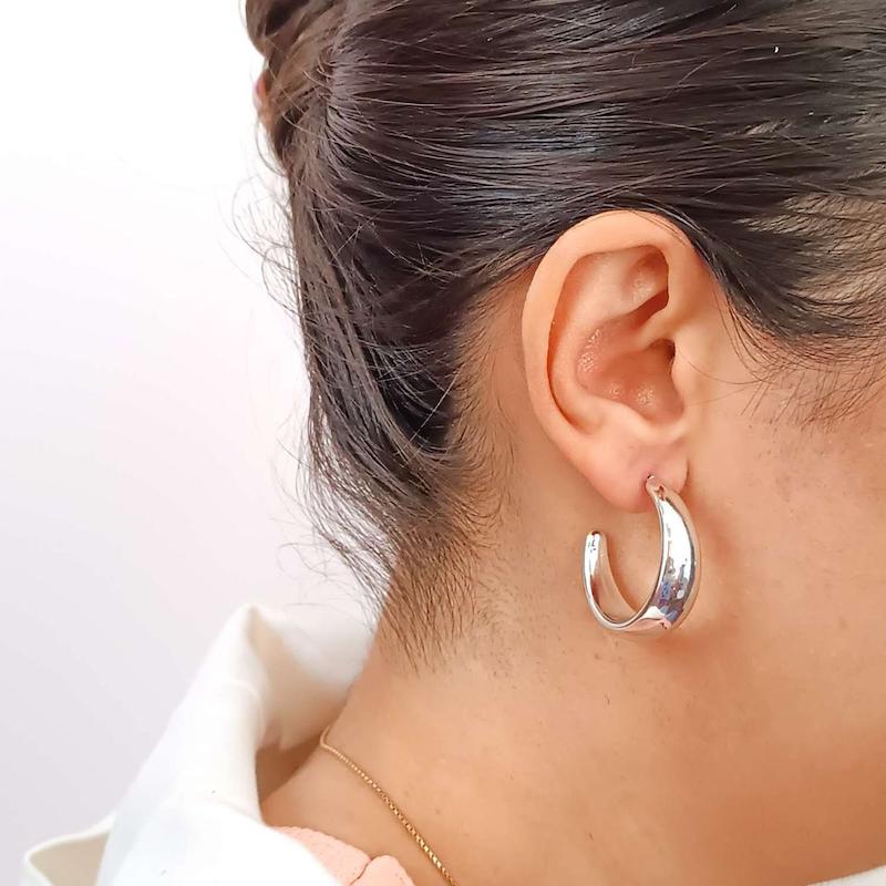 گوشواره زنانه هلالی نقره ای با آبکاری براق در گوش دختر