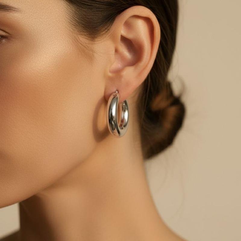 گوشواره دامله هلالی نقره‌ای روی گوش مدل زنانه – طراحی منحنی و براق با جلوه‌ی مدرن و ساده