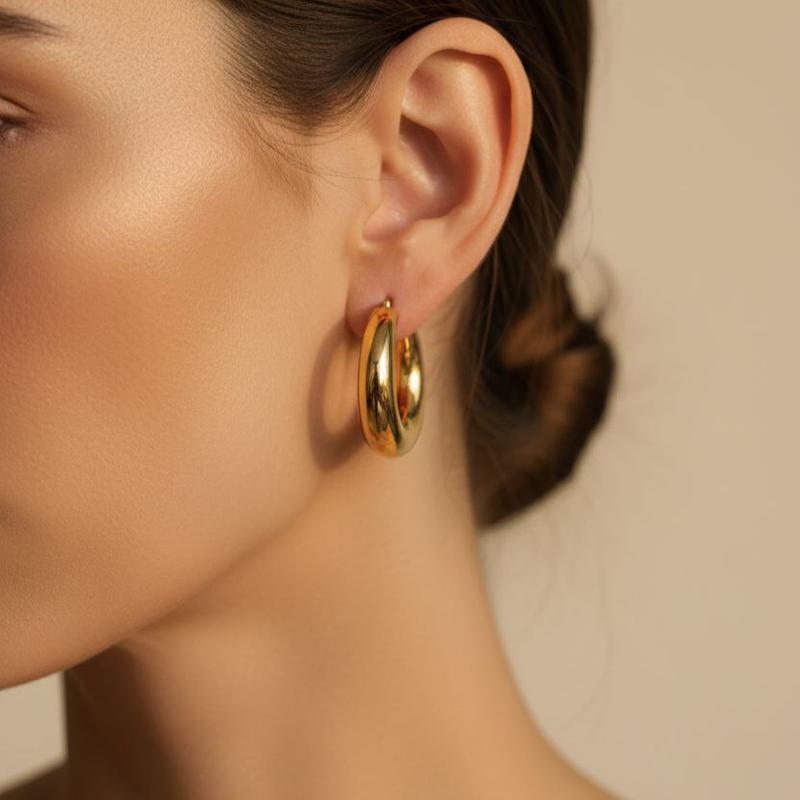 گوشواره دامله هلالی طلایی روی گوش مدل زنانه – طراحی براق و مینیمال با فرم حجیم و سطح صیقلی