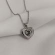 گردنبند قلبی لیزری استیل نقره‌ای روی زمینه‌ی پارچه سفید