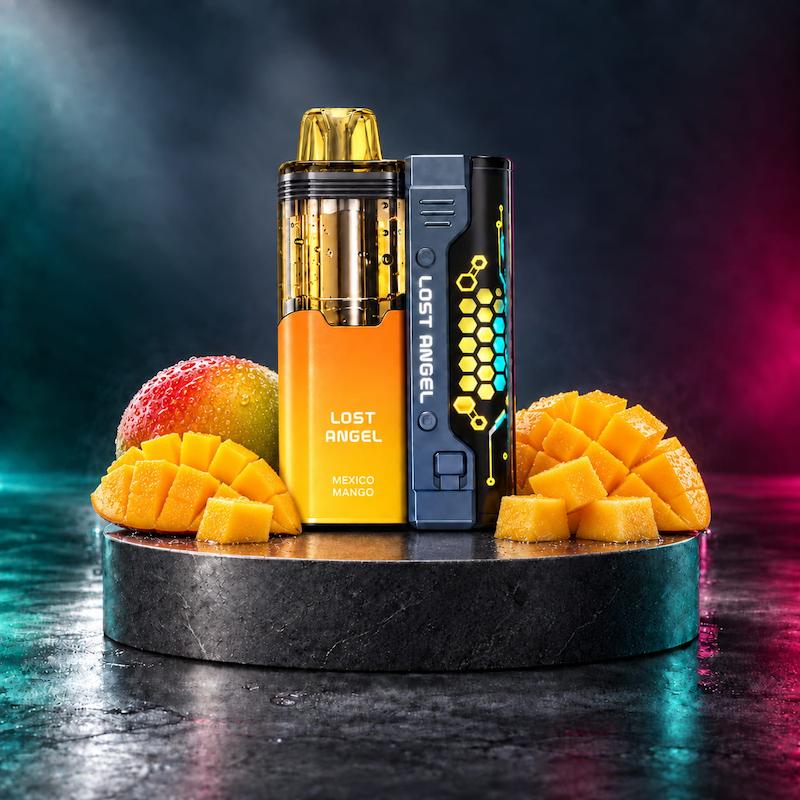 پاد لاست انجل Mate 50K طعم انبه مکزیکی کنار انبه رسیده و برش‌های انبه روی استند تیره