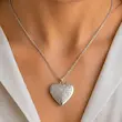 گردنبند لاکت طرح دار قلم زنی نقره ای قلب زنانه روی گردن مدل با لباس سفید