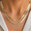 گردنبند ماری زنانه استیل در دو رنگ نقره ای و طلایی روی گردن مدل زن با لباس سفید