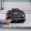 فردی در حال تنظیم برنامه پخت گوشت (Beef) بر روی پنل کنترل دیجیتال و هوشمند گریل نینجا مدل AG551.
