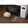 مایکروویو هایسنس مدل H20MOWS4 در کنار یک کاسه پاپ‌کورن تازه.