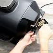 اضافه کردن پلت‌های چوب برای ایجاد طعم دودی در گریل باربیکیو برقی نینجا مدل OG850.