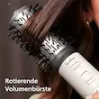 برس چرخشی ۵۰ میلی‌متری سشوار چرخشی فیلیپس مدل BHA710 در حال حجم دادن به یک دسته موی قهوه‌ای.