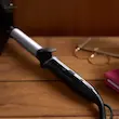حالت دهنده فیلیپس مدل BHB86400 به صورت روشن روی میز چوبی در کنار عینک و دفترچه یادداشت.