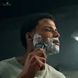 مردی در حال اصلاح مرطوب صورت خود با کف، با استفاده از ماشین اصلاح صورت فیلیپس مدل S5898/35.