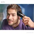 مردی خندان در حال استفاده از ماشین اصلاح فیلیپس مدل HC9420/15 برای کوتاه کردن موهای کنار سر خود.