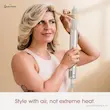 زنی با موهای بلوند لخت در حال استفاده از فر کننده خودکار سشوار شارک نینجا HD430 برای حالت دادن مو با هوا.