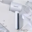 بخارگر پاناسونیک مدل NI-GHD015 به زیبایی روی یک میز سفید در کنار اکسسوری‌های شخصی قرار گرفته است.