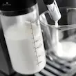 کلوزآپ از سیستم کف شیر ساز LatteCrema اسپرسو ساز دلونگی مدل ECAM290.83 در حال ریختن شیر.