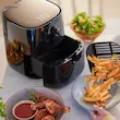 فردی در حال ریختن سیب‌زمینی سرخ‌شده طلایی از سبد سرخ کن بدون روغن فیلیپس مدل HD9200 داخل بشقاب.