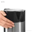 دست فرد در حال لمس بدنه دوجداره کتری برقی بوش مدل TWK7203 که عایق گرما است.