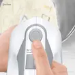 دست یک فرد در حال فشردن دکمه اجکت خاکستری روی همزن دستی بوش مدل MFQ364V0.