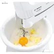همزن دستی بوش مدل MFQ36400 با سری خمیرزن در حال مخلوط کردن آرد، تخم مرغ و کره در کاسه.