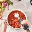 یک دست در حال پوره کردن سوپ گوجه فرنگی در قابلمه با گوشت کوب برقی براون مدل MQ5275.