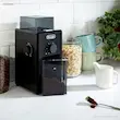 آسیاب قهوه دلونگی مدل KG79 در یک آشپزخانه مدرن به همراه قهوه آسیاب شده.
