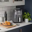 بشقاب غذای آماده شامل ذرت و مرغ سوخاری کنار سرخ کن بدون روغن نینجا مدل AF160 روی پیشخوان.