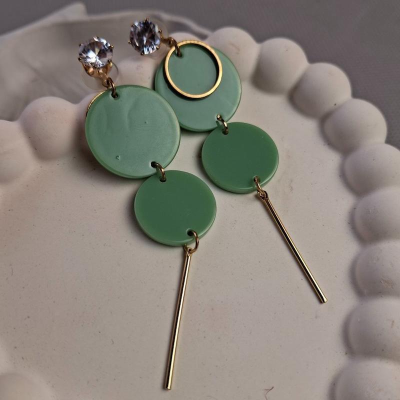 گوشواره آویز دایره‌های سبز مات با نگین براق و میله طلایی – مدل مدرن و مینیمال