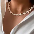 گردنبند ستاره دریایی سفید دخترانه با مهره های طلایی شیک روی گردن مدل
