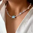 گردنبند ساحلی صدف طبیعی با ستاره دریایی آبی و سنگ آبی ماربُل روی گردن مدل