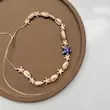 گردنبند صدف کاوری طبیعی با ستاره دریایی سفید و آویز ستاره دریایی آبی-بنفش دخترانه از نمای نزدیک