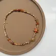 گردنبند ساحلی صدف حلزون و ستاره دریایی نارنجی با سنگ آونتورین از نمای نزدیک