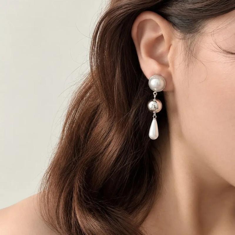 گوشواره آویز مرواریدی نقره‌ای با آویز اشکی سفید روی گوش