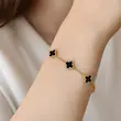 نمای دستبند طلایی ونکلیف گل مشکی روی مچ دست