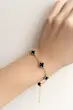 نمای دستبند طلایی ونکلیف گل مشکی روی مچ دست