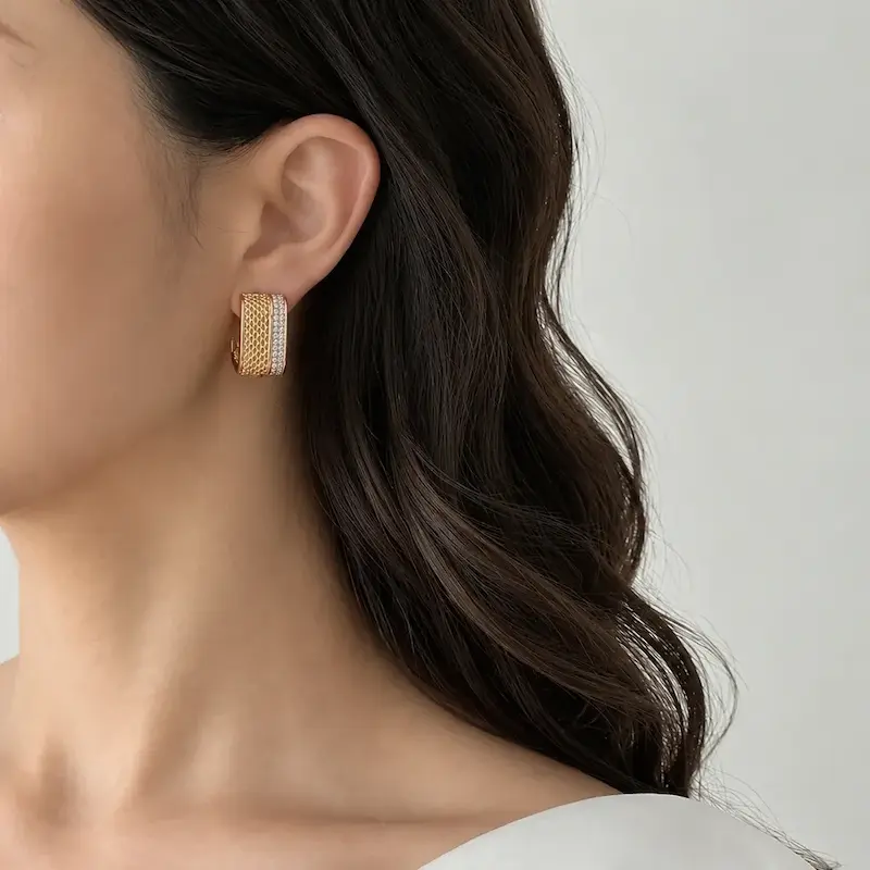 گوشواره حلقه‌ای پهن بافت‌دار و نگین‌دار ژوپینگ با آبکاری طلا روی گوش مدل
