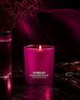 شمع معطر Strawberry Éclair سراد با ظرف صورتی در فضای تاریک