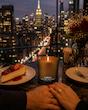 شمع New York Cheesecake سراد با رایحه وانیلی و بیسکویتی در فضای شام و منظره شهری